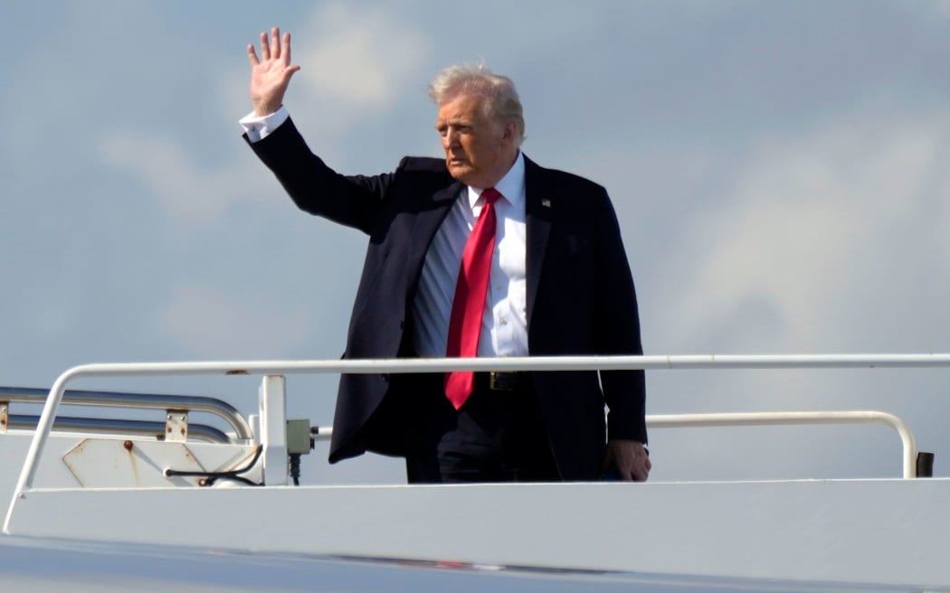 President Donald Trump waves as he boards Air Force One at Palm Beach International Airport in West Palm Beach, Florida on Sunday, 9 February.