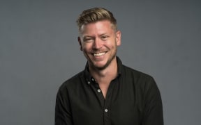 Matt Gibb is a smiling blonde haired man in a black shirt.