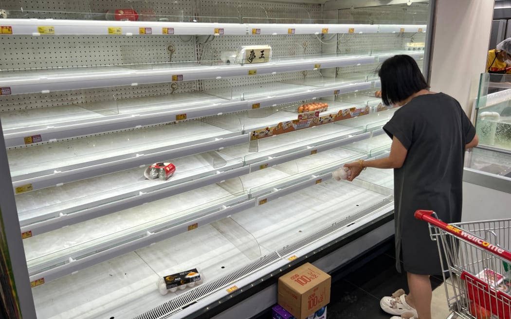 A woman is looking to buy eggs at a supermarket as Super Typhoon Ragasa approaches to Hong Kong, on September 23, 2025. Hong Kong rushed to prepare for the arrival of Super Typhoon Ragasa, with officials warning of a "serious threat" comparable to some of the most destructive storms in the city's recent history. (Photo by Mladen ANTONOV / AFP)