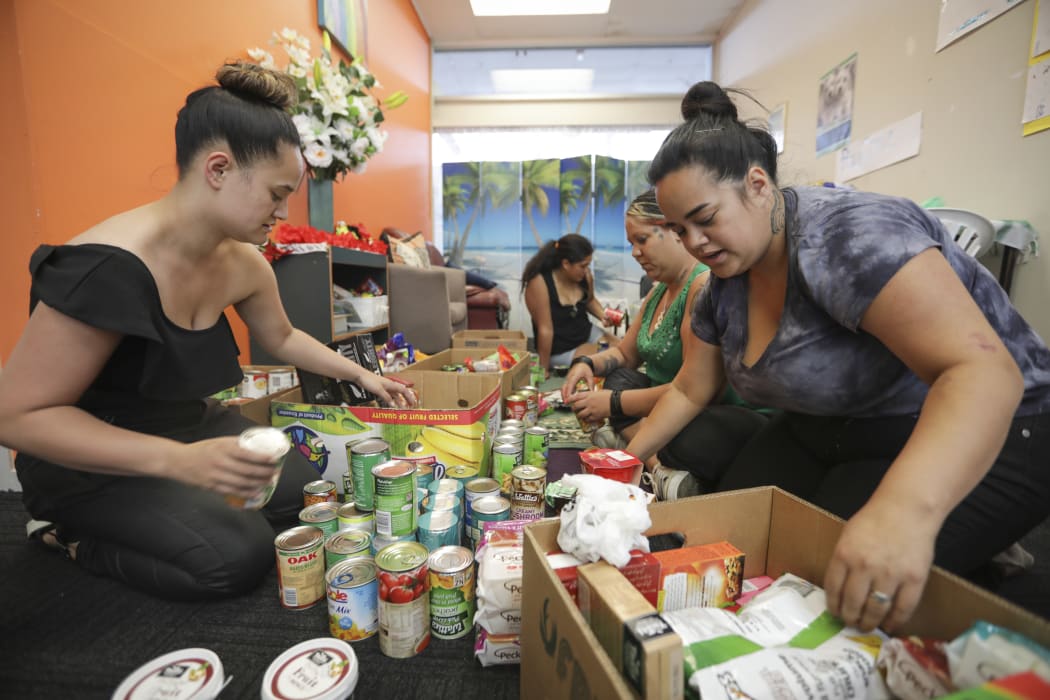 Waitangirua community members pack donations. Locals received a free sausage sizzle, some received food hampers and christmas gifts were handed out to the children.