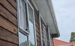 A house that had its window broken after gunshots were fired in the Auckland suburb of Point England.