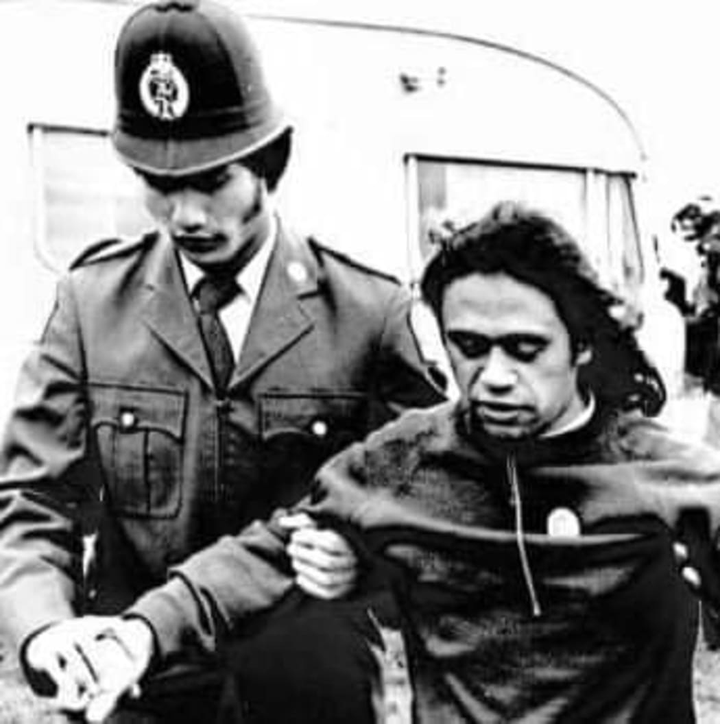 Masunu in Police Uniform taking a man away during the Dawn raids