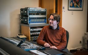 Composer William Philipson sits in his studio