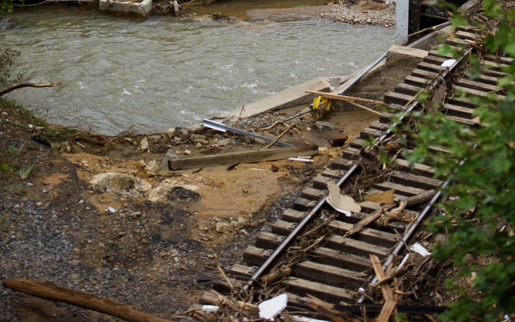 OLD FORT, NORTH CAROLINA - SEPTEMBER 30: Railroad tracks, homes, and vehicles are destroyed in the aftermath of Hurricane Helene on September 30, 2024 in Old Fort, North Carolina. According to reports, at least 100 people have been killed across the southeastern U.S., and millions are without power due to the storm, which made landfall as a Category 4 hurricane on Thursday. The White House has approved disaster declarations in North Carolina, Florida, South Carolina, Tennessee, Georgia, Virginia and Alabama, freeing up federal emergency management money and resources for those states.   Melissa Sue Gerrits/Getty Images/AFP (Photo by Melissa Sue Gerrits / GETTY IMAGES NORTH AMERICA / Getty Images via AFP)