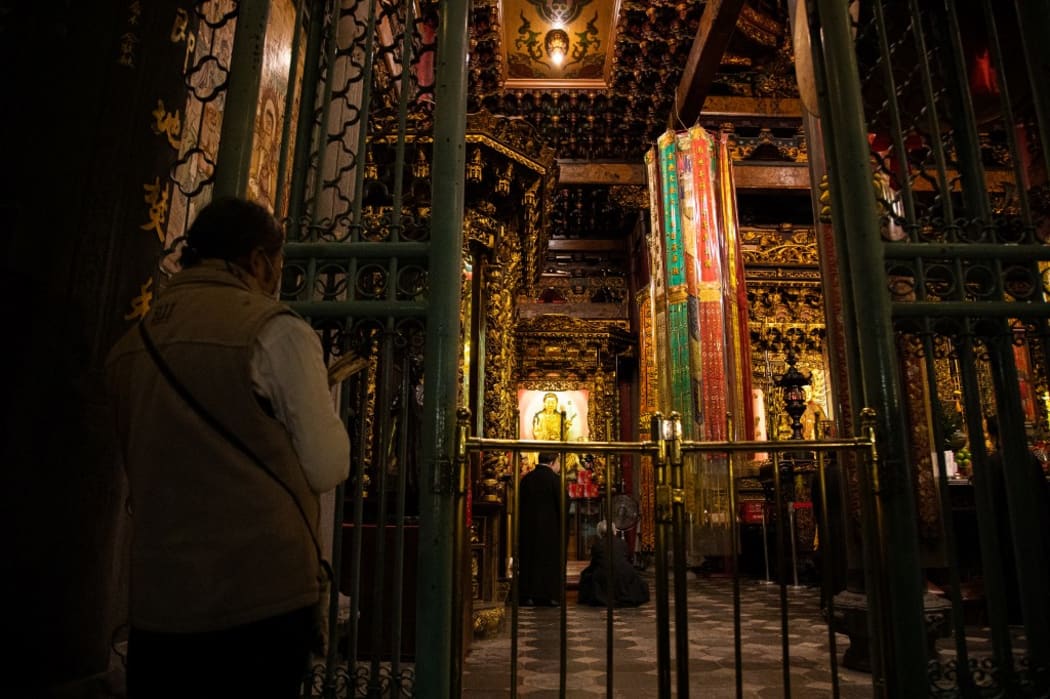 People wearing facemasks praying at Longshan Temple on Chinese Lunar New Year's Eve amid Covid-19 pandemic in Taipei, Taiwan on 11 Feb 2021. (Photo by Annabelle Chih/NurPhoto) (Photo by Annabelle Chih / NurPhoto / NurPhoto via AFP)