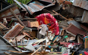 A man looks for his belongings amid the debris of his destroyed house in Palu in Central Sulawesi on September 29, 2018, after a strong earthquake and tsunami struck the area.
