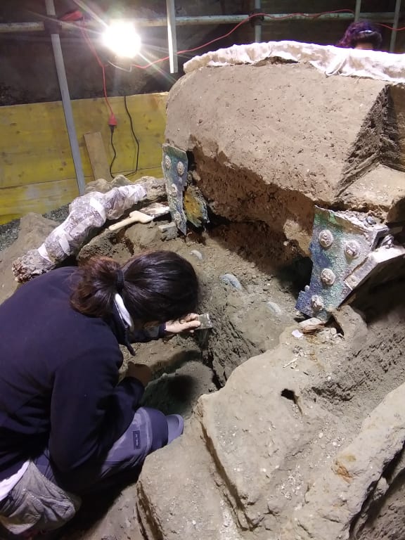 An archaeologist working at the site where a large Roman four-wheeled ceremonial chariot was discovered near the The archaeological park of Pompeii.