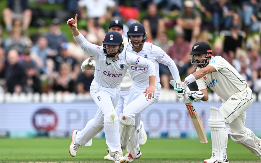 Ollie Pope of England celebrates after taking a close in catch to dismiss Daryl Mitchell of New Zealand.