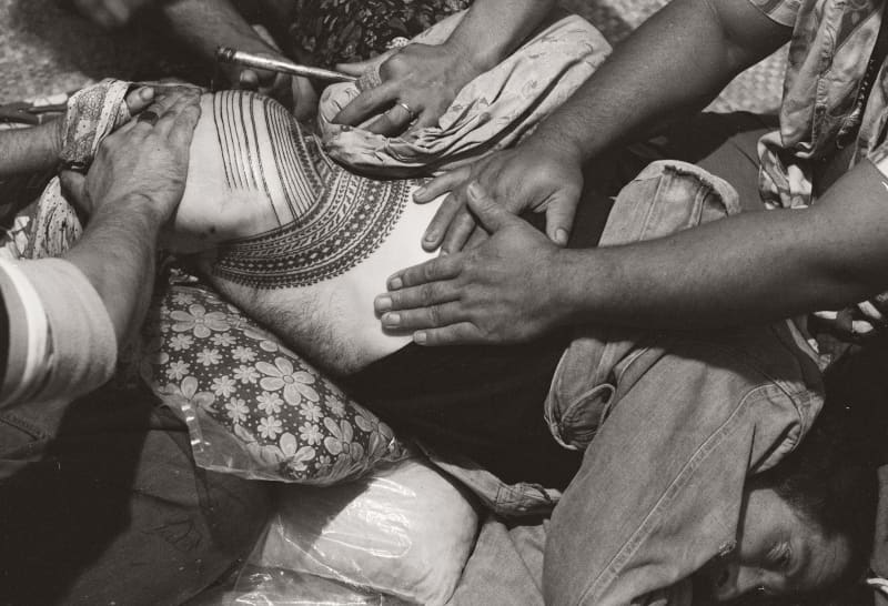 Artist Tony Fomison receiving a pe‘a (traditional waist to knee tattoo) from Samoan master tattooist Paulo Sulu‘ape II in 1979.
