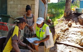 A Papua New Guinea census official helping people fill out census forms for the 2021 census, in 2020.