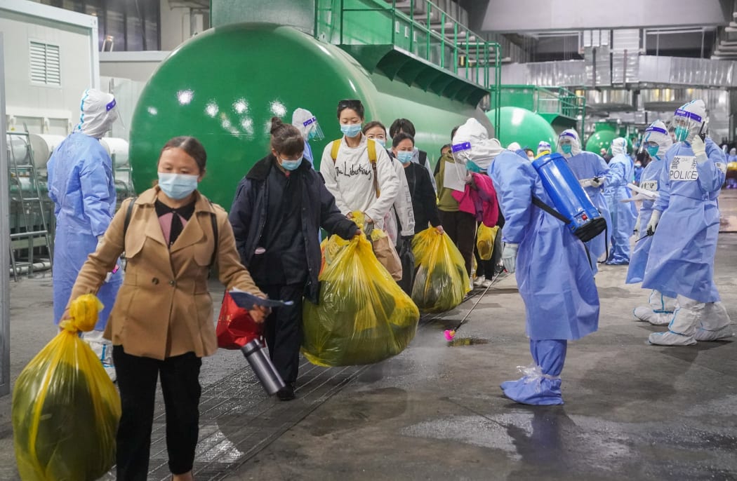Covid-19 patients leave the National Exhibition and Convention Center (NECC), the largest makeshift hospital, in east China's Shanghai, April 14, 2022.