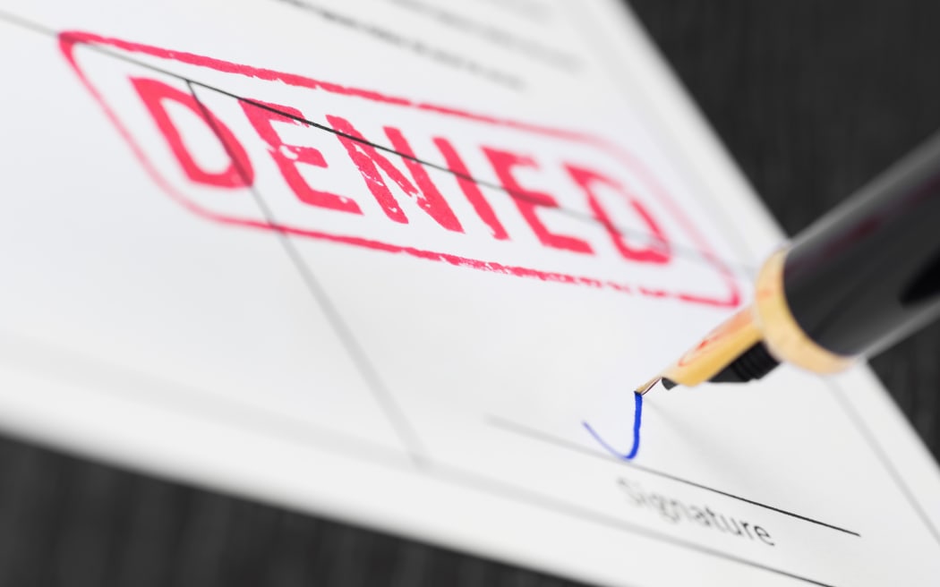 Seal denied stamped on a document and fountain pen. Macro shot.