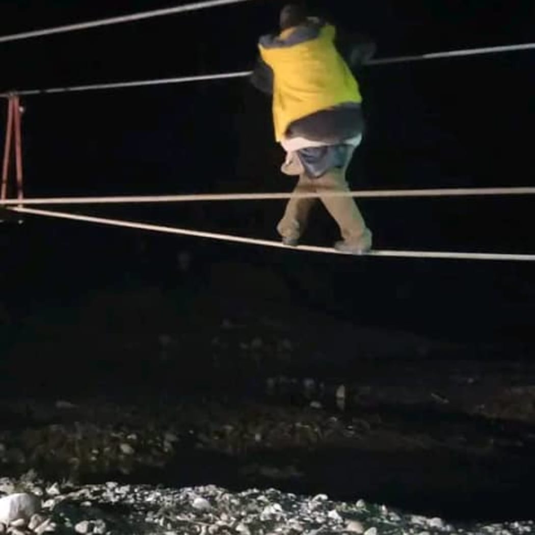 Dickson Tanda crossing rhe Lai river at night carrying rescued woman on his back. September, 2022.