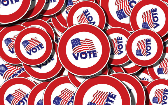 Badges with the American flag a "vote" written on them