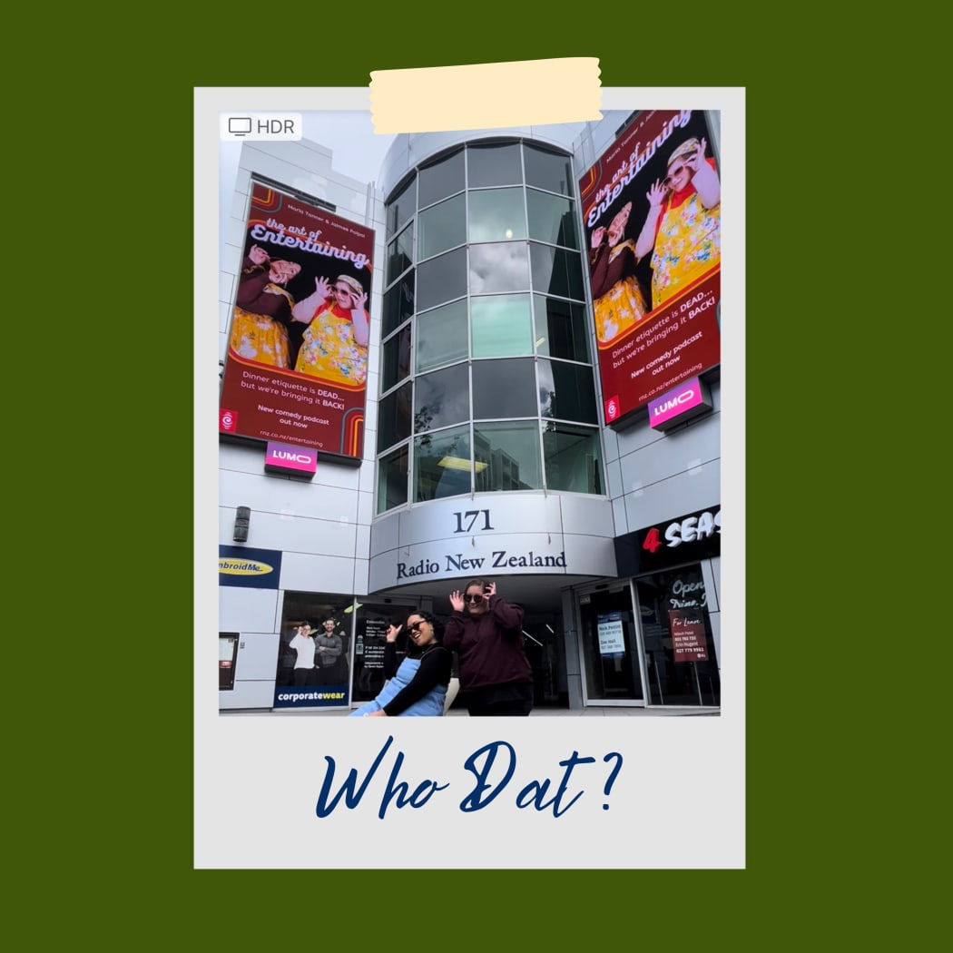 A photo of the front of the RNZ building in Auckland. On either side of the building are two digital buildboards each showing the promotional image for The Art of Entertaining which features the two hosts Jaimee and Maria in 70s style clothing and glasses. The hosts themselves are standing in front of the building and their own billboards, posing with glasses in a similar way to what is depicted on the billboards. The caption read: ''Who Dat?''