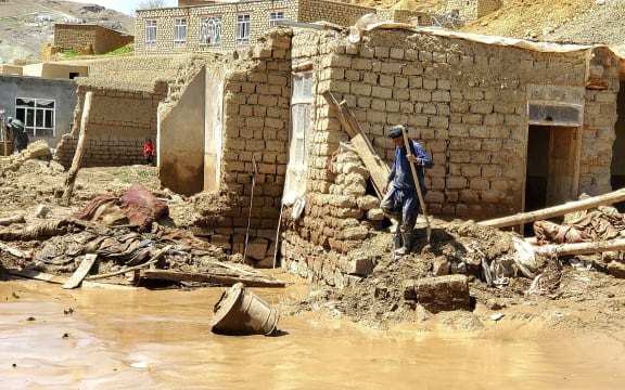 An Afghan man collects his belongings from his damaged home after heavy flooding in Ghor province in western Afghanistan, Saturday, May 18, 2024. Flash floods from heavy seasonal rains in Ghor province killed dozens of people and dozens remain missing, a Taliban official said on Saturday, adding the death toll was based on preliminary reports and might rise.