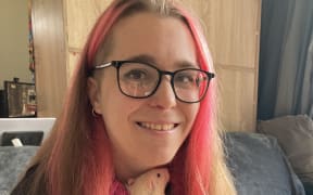 Belinda Clarke has pink and blonde hair. She is holding a rat.