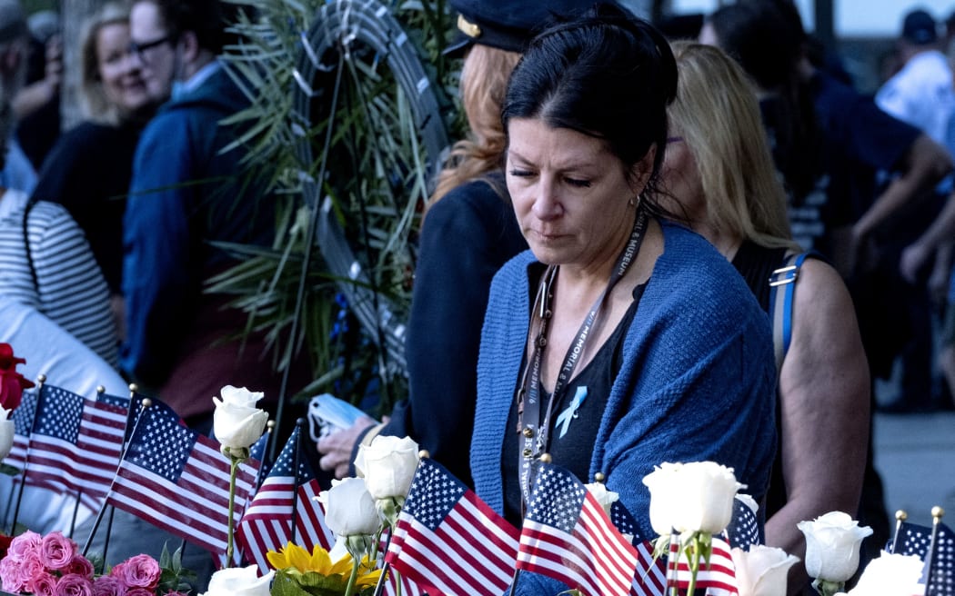 Julie Sweeney Roth, whose husband Brian Sweeney Roth died when United Airlines flight 175 hit the World Trade Center on Sept. 11, 2001, touches his name at the 9/11 Memorial and Museum on September 11, 2021 in New York City.