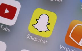 FILE- This Aug. 9, 2017, file photo shows the Snapchat app on a mobile device in New York.