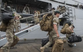 Army personnel disembark from the HMNZS Canterbury.