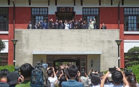 This picture taken by Taiwan’s Central News Agency (CNA) shows US House Speaker Nancy Pelosi and other officials waving to journalists at the Parliament in Taipei on August 3, 2022.