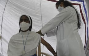 A health worker inoculates a Catholic nun with the first dose of the Covaxin vaccine against the Covid-19 coronavirus during a vaccination drive at Saint Mary's Basilica in Secunderabad, the twin city of Hyderabad on August 19, 2021.