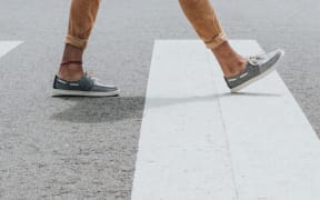 a pair of legs crossing a road