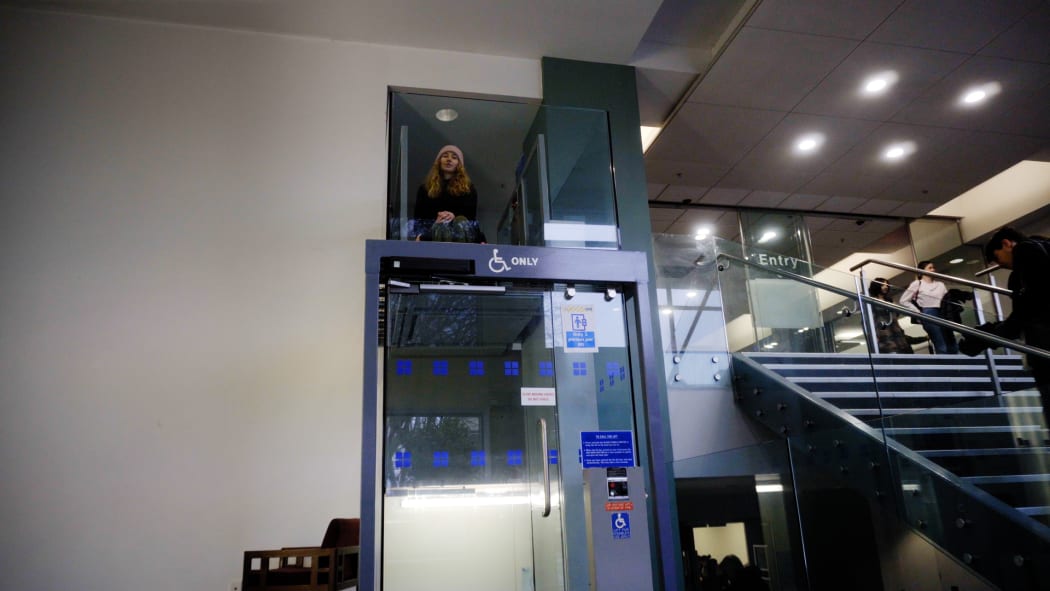 Pieta Bouma sits at the top of a glass-walled lift.
