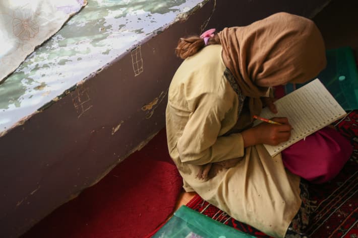 This picture taken on July 25, 2022 shows a girl studying in a secret school at an undisclosed location in Afghanistan.