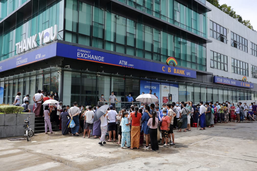 People queue for a long time to withdraw money from ATM machines of CB Bank at the downtown area in Yangon on April 30, 2021 following the Myanmar military coup in early February.