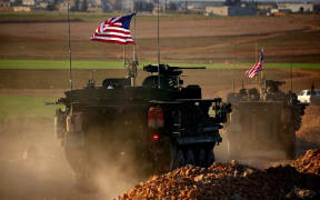 A convoy of US forces armoured vehicles on the western outskirts of the northern Syrian city of Manbij in March.