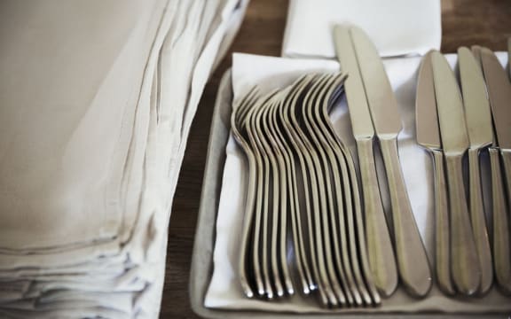 [England] High angle close up of napkins and silver forks and knives on a table in a restaurant. (Photo by Mint Images / Mint Images / Mint Images via AFP)