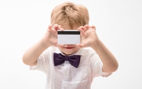 Boy showing blank credit card. Credit card. Cash. Business-card. Plastic bank card with magstripe. Empty credit card. Cashless calculation. Bank concept. Copy space for bank advertising.