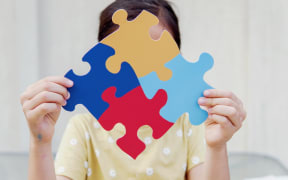 Kid girl hands holding puzzle jigsaw,  mental health concept, world autism awareness day