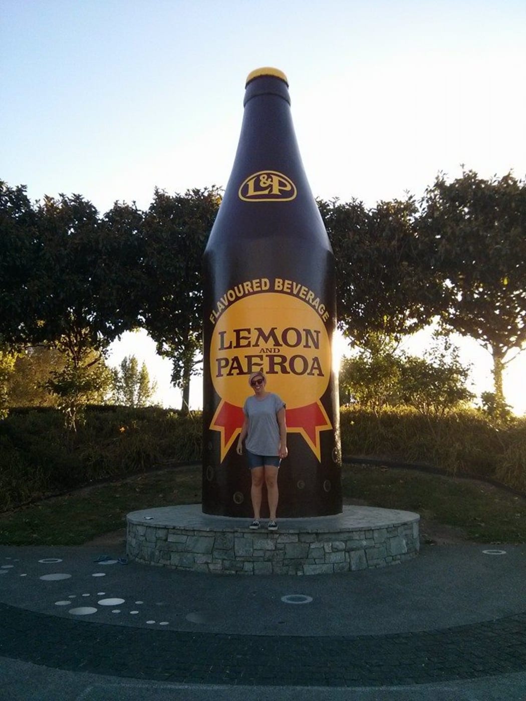 A picture of Claire Adamson back home in New Zealand, at the giant L&P bottle in Paeroa