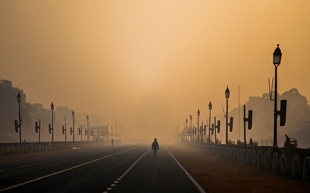 A man walks along Rajpath amid smoggy conditions in New Delhi on January 28, 2021.