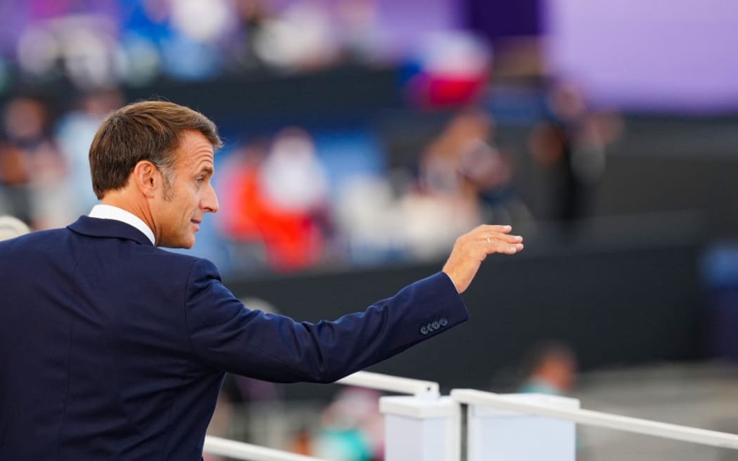 El presidente francés, Emmanuel Macron, saluda mientras asiste a la ceremonia de apertura de los Juegos Paralímpicos París 2024 el 28 de agosto de 2024 en París. (Foto de Dimitar Tilkoff/AFP)