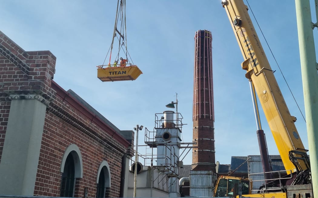 The chimney at the Dunedin Gasworks Museum, with machinery nearby.