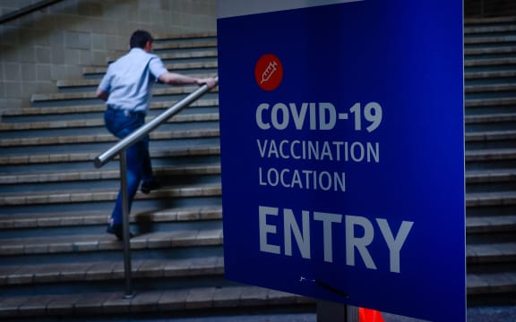A man walks past signage at a Covid-19 vaccination hub at the Brisbane Convention and Exhibition Centre.