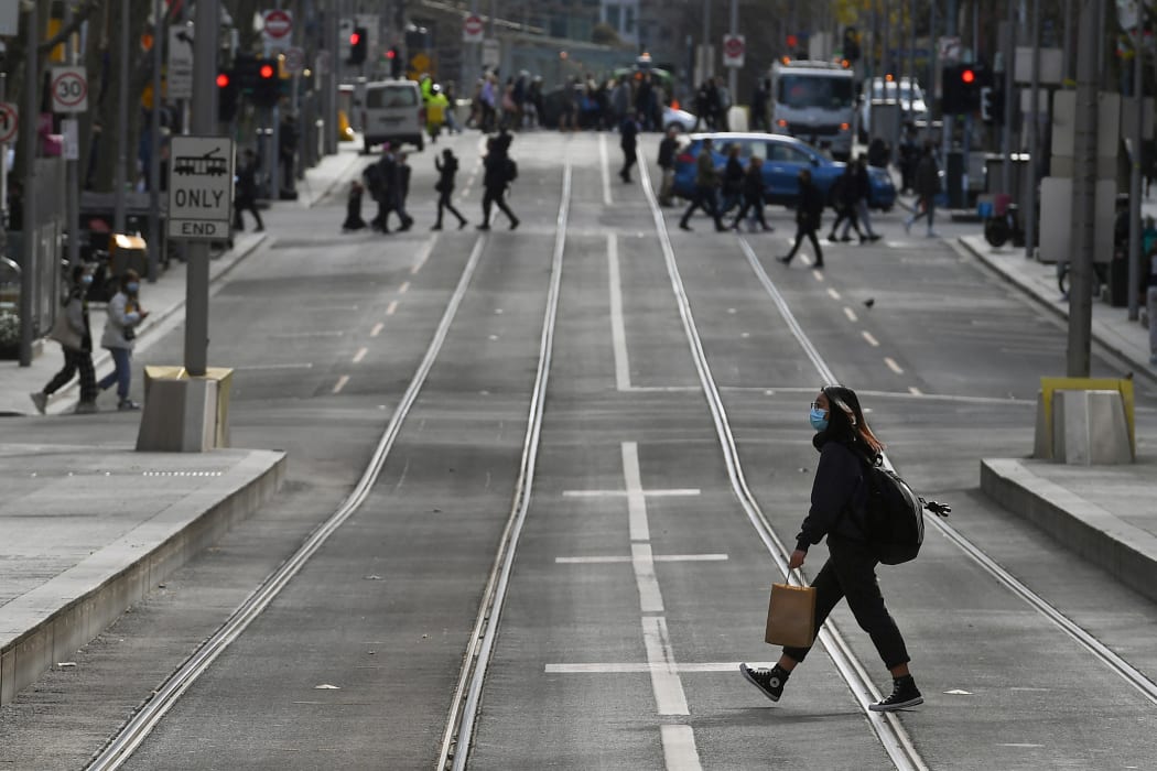A shopper crosses the street in the central business district in Melbourne on July 7, 2021