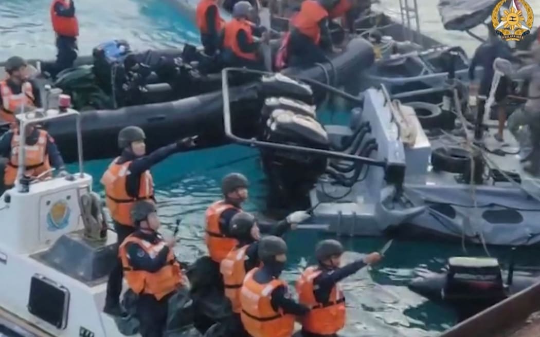 This frame grab from handout video taken on June 17, 2024 and released by the Armed Forces of the Philippines Public Affairs Office on June 19 shows China coast guard personnel appearing to wield bladed weapons during an incident off Second Thomas Shoal in the South China Sea. The Philippine military said on June 19 the Chinese coast guard rammed and boarded Filipino navy boats in a violent confrontation in the South China Sea this week in which a Filipino sailor lost a thumb. China defended its actions, with its foreign ministry saying on Wednesday that "no direct measures" were taken against Filipino personnel. (Photo by Handout / ARMED FORCES OF THE PHILIPPINES-PUBLIC AFFAIRS OFFICE / AFP) / -----EDITORS NOTE --- RESTRICTED TO EDITORIAL USE - MANDATORY CREDIT "AFP PHOTO / ARMED FORCES OF THE PHILIPPINES - PUBLIC AFFAIRS OFFICE" - NO MARKETING - NO ADVERTISING CAMPAIGNS - DISTRIBUTED AS A SERVICE TO CLIENTS