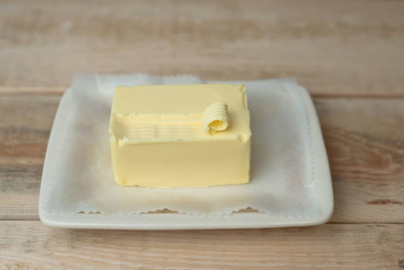 A block of butter on a white dish.