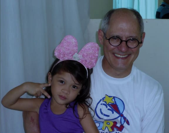 Tristan De Chalain from Operation Hope with a little girl in the Philippines whose face he repaired.
