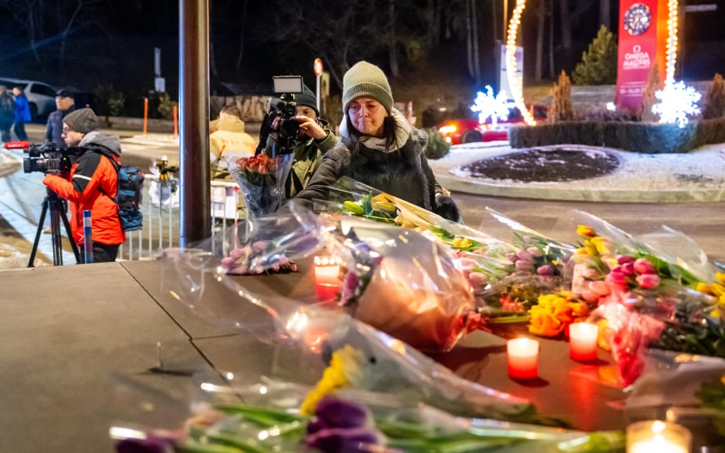 A woman lays flowers near the site where a fire ripped through a crowded bar during New Year's Eve celebrations in the Alpine ski resort town of Crans-Montana on January 1, 2026. Several dozen people are presumed dead and around 100 injured after a fire ripped through a crowded bar in the luxury Swiss ski resort of Crans-Montana, Swiss police said on January 1, 2026. Police, firefighters and rescuers rushed to the popular resort, which is set to host the Ski World Cup from January 30, after the fire broke out in the early hours of New Year's Day. (Photo by MAXIME SCHMID / AFP)
