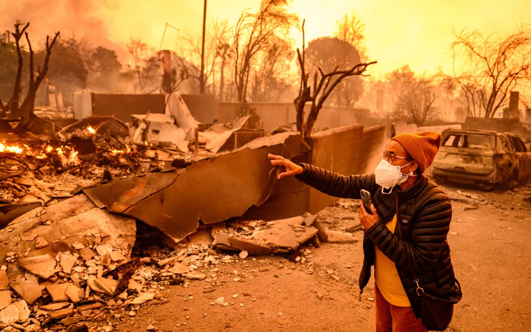 Margaret Larkin views her burned home during the Eaton fire in the Altadena area of Los Angeles county, California on January 8, 2025. - At least five people are now known to have died in wildfires raging around Los Angeles, with more deaths feared, law enforcement said January 8, as terrifying blazes leveled whole streets, torching cars and houses in minutes.
More than 1,000 buildings have burned in multiple wildfires that have erupted around America's second biggest city, forcing tens of thousands of people from their homes. (Photo by JOSH EDELSON / AFP)