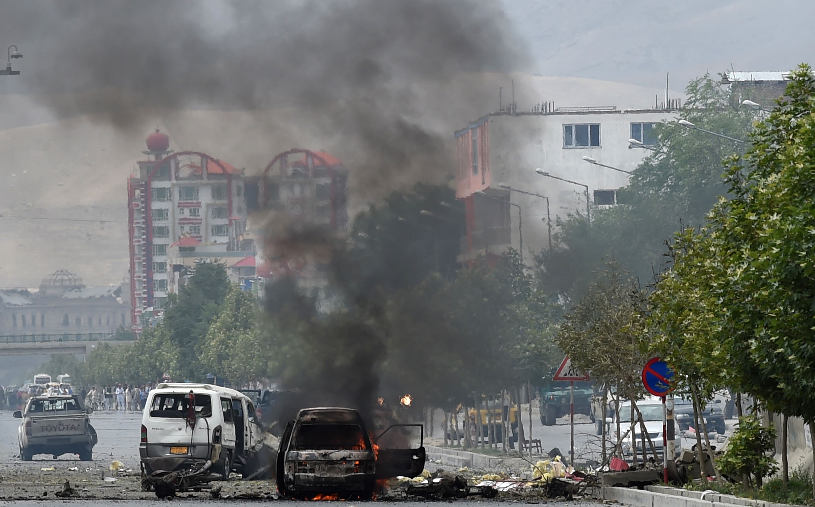 Smoke and flames rise from burning vehicles at the site of the attack in front of the Afghan Parliament in Kabul on 22 June 2015.