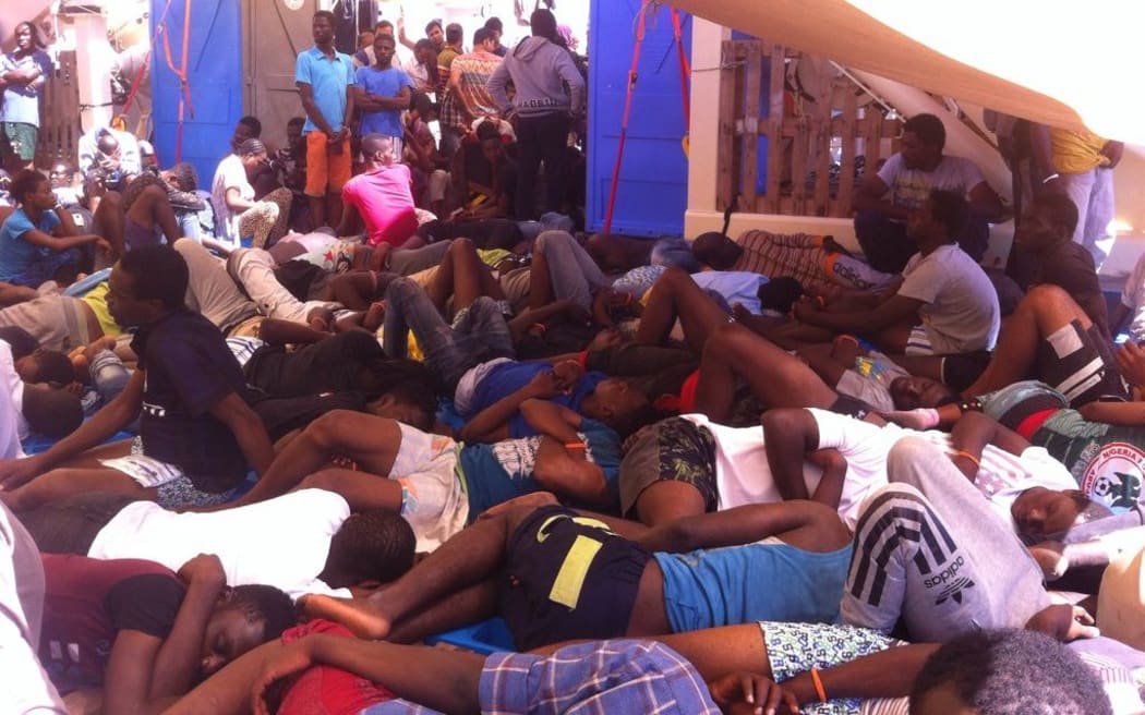 People rest in the shade on the Responder after being rescued.
