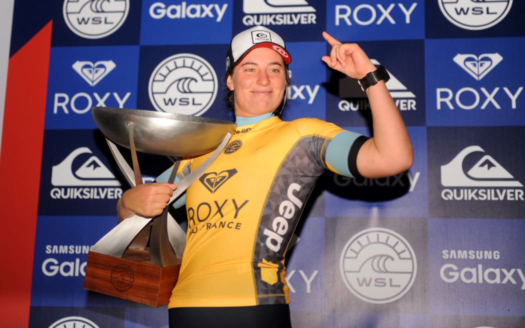 Australia's Tyler Wright celebrates with her trophy after winning the world title after competing in the French stage of the World Surf League in Hossegor, on October 12, 2016. (Photo by Gaizka IROZ / AFP).