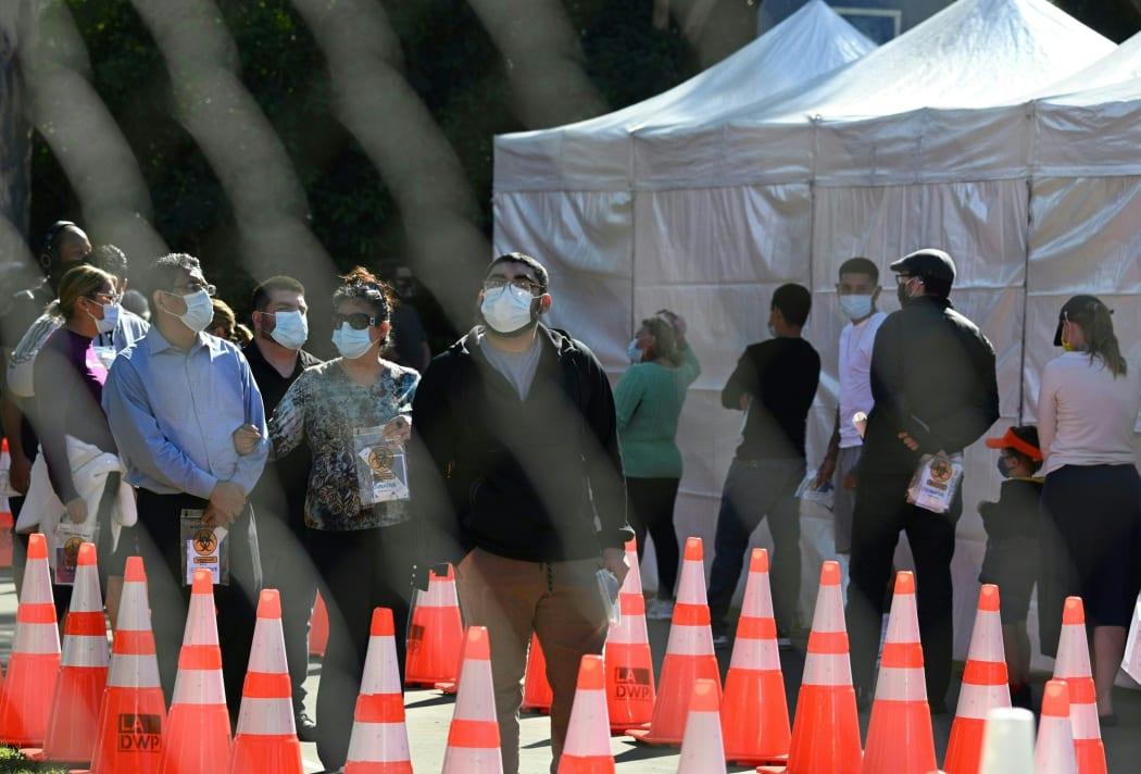 People wait in long lines for covid tests at a walk-up Covid-19 testing site in San Fernando, California.