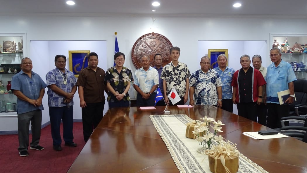 Foreign Minister Casten Nemra, third from left, and Japan Ambassador Norio Saito, fourth from left, signed an agreement in Majuro